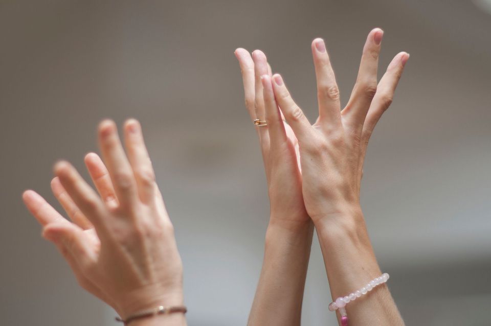 Løftede hender med armbånd