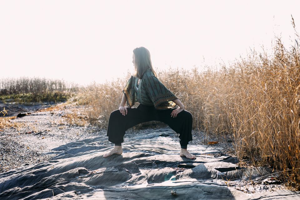 Marthe Magerøy sitter på huk på en strandberg i gyllent siv, under en lys høsthimmel