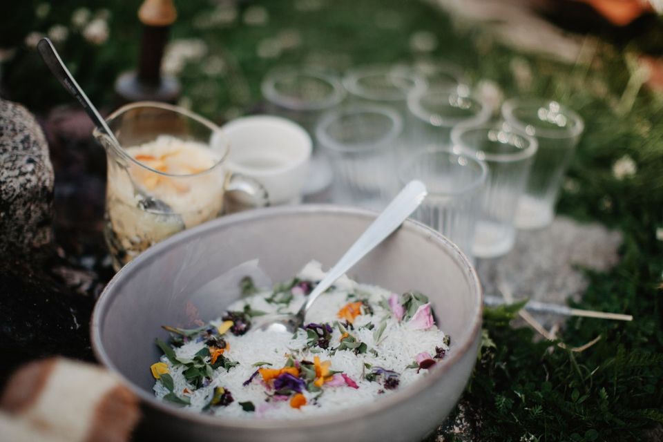 Skåler med salat pyntet med spiselige blomster på et bord ute